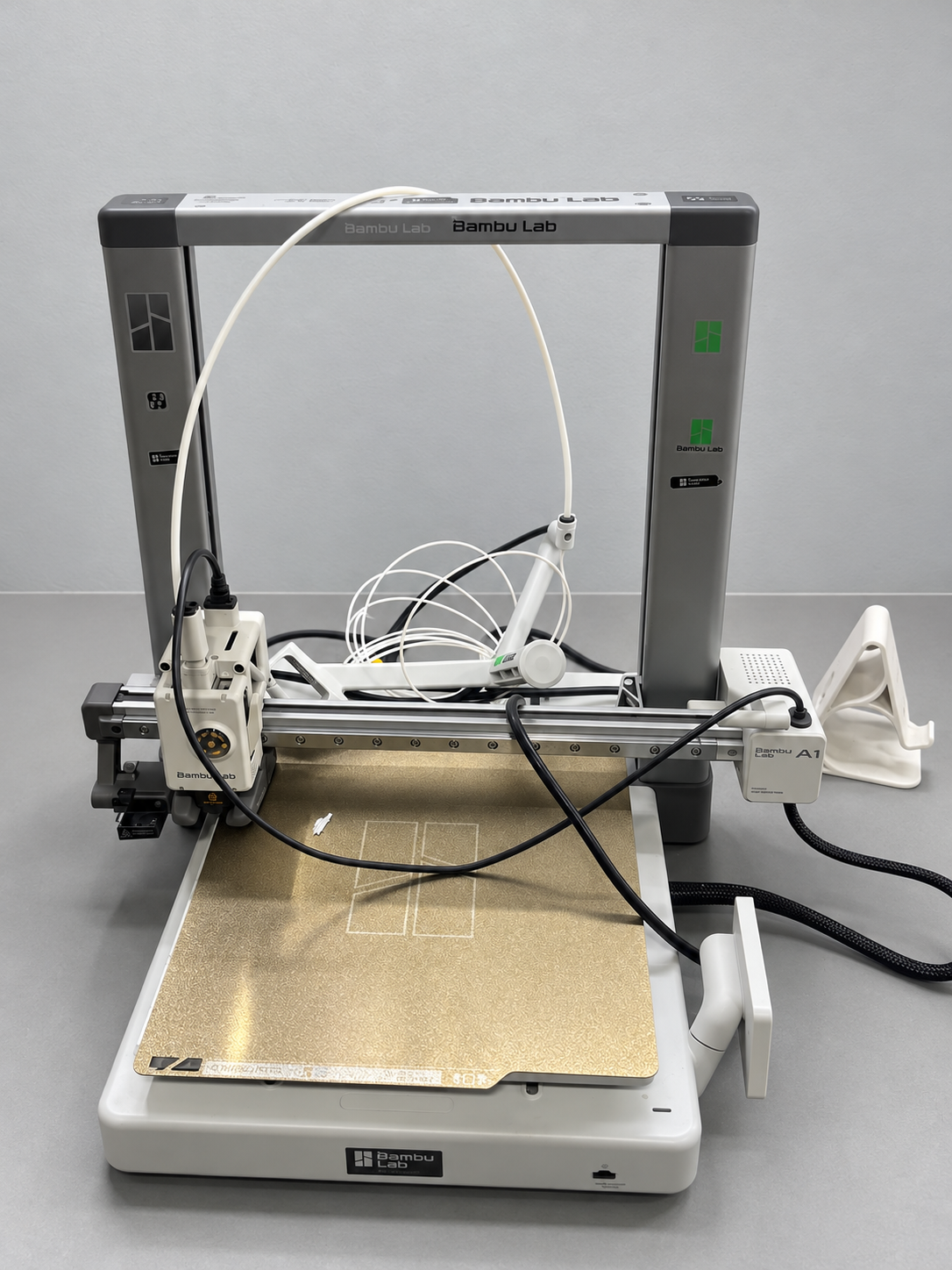 Segunda Bambu Lab A1 na bancada, com tubo PTFE e filamento branco junto ao conjunto